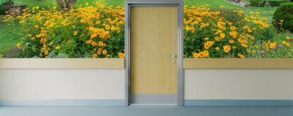 Black Eyed Susan Wallpaper, as seen on the wall of this assisted living hallway, is a photo mural of yellow flowers in a garden from About Murals.