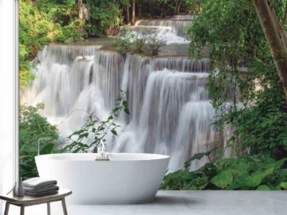 Nature Waterfall Wallpaper, as seen on the wall of this bathroom, is a photo mural of water cascading over rock surrounded by beautiful green trees in a forest from About Murals.