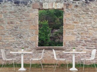 Forest Window View Wallpaper, as seen on the wall of this restaurant, is a high resolution photo mural of a stone garden wall with an opening looking out onto green trees from About Murals.