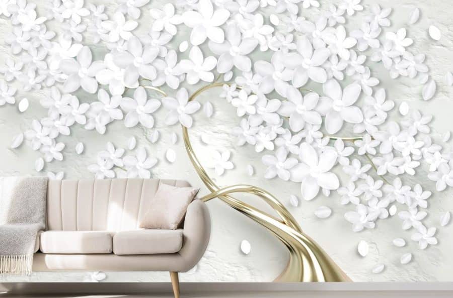 White Flower Tree Wallpaper, as seen on the wall of this living room, is a wall mural with white blossoms sitting atop a gold tree trunk from About Murals.