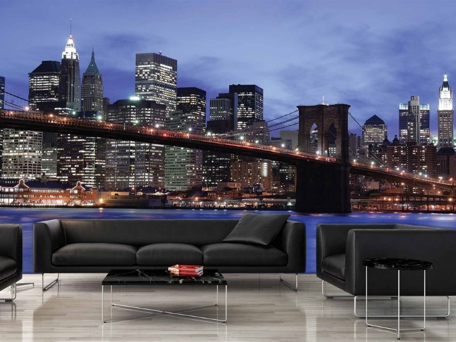 NYC Skyline Wallpaper, as seen on the wall of this blue living room, is a photo mural of the black Brooklyn Bridge contrasted against a blue night sky in New York from About Murals.