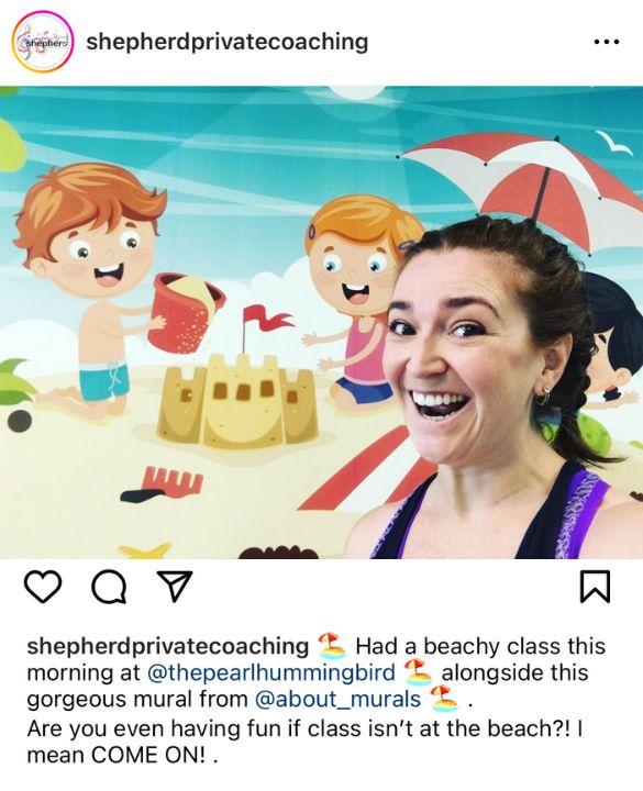 A photo of sustainable wallpaper features a teacher standing in front of a kids mural from Shepherd Private Coaching, supplied by About Murals.