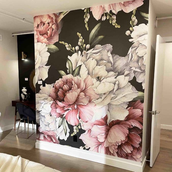 Black and Pink Floral Wallpaper, as seen on the wall of this hallway, is a modern mural with large peony flowers on a dark background from About Murals.