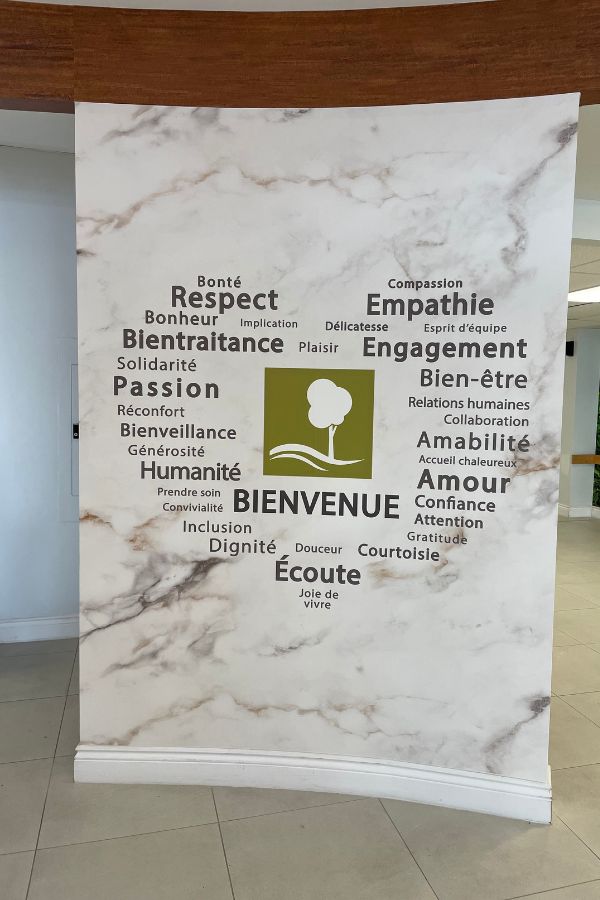 Lobby wallpaper, as seen on this care home wall, with value statement words written on a marble background.