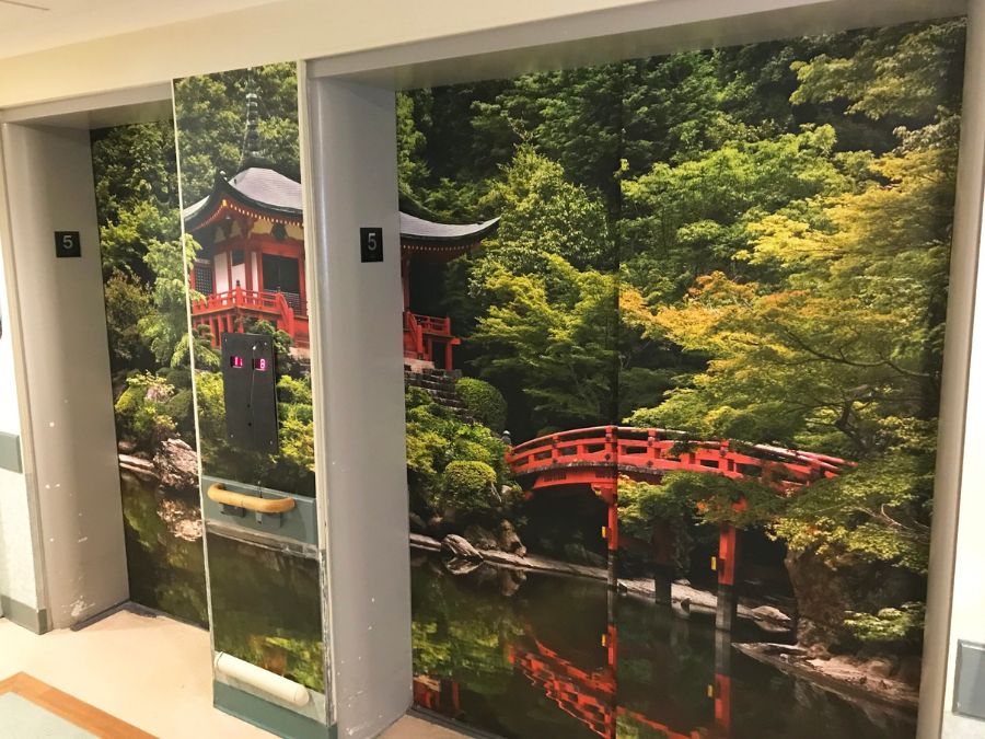 Wayfinding wallpaper, such as this Japanese Temple Mural on elevator doors in a care home, is a great way to know which floor a resident is on when navigating a large facility.  Wayfinding wallpaper sold by About Murals.