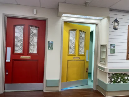 Dementia Door Wrap, as seen on two resident bedroom doors, in red and yellow colour in a memory care unit from About Murals