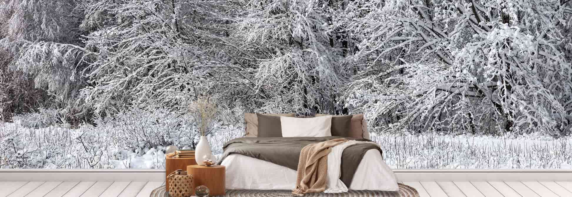 Winter Wallpaper, as seen on the wall of this bedroom, is a photo wall mural of a winter scene with snow covered trees in a forest from About Murals