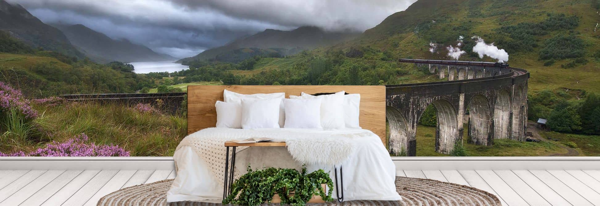 Train wallpaper mural, as seen on the wall of this bedroom, features a steam locomotive on tall bridge under stormy skies from About Murals.