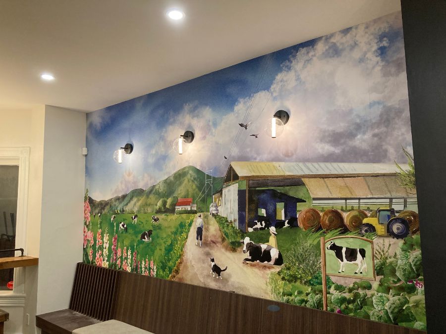 Eco wallpaper for healthy restaurants like an earth to table or vegan menu, featuring a farm scene, on the wall behind banquette seating from About Murals.